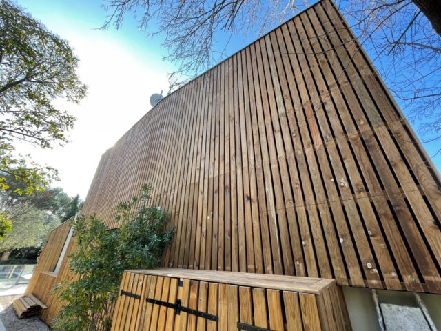 Bardage claire-voie en pin français avec couvertine en zinc